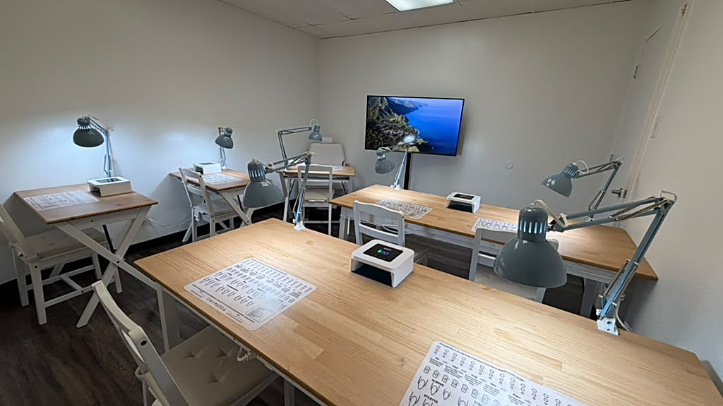 Salón de alquiler equipado con mesas de práctica y pantalla